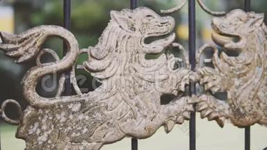古老的皇家豪华宫殿的锻铁<strong>门</strong>上有两只金雕狮子，摄像机慢慢地旋转和滑动